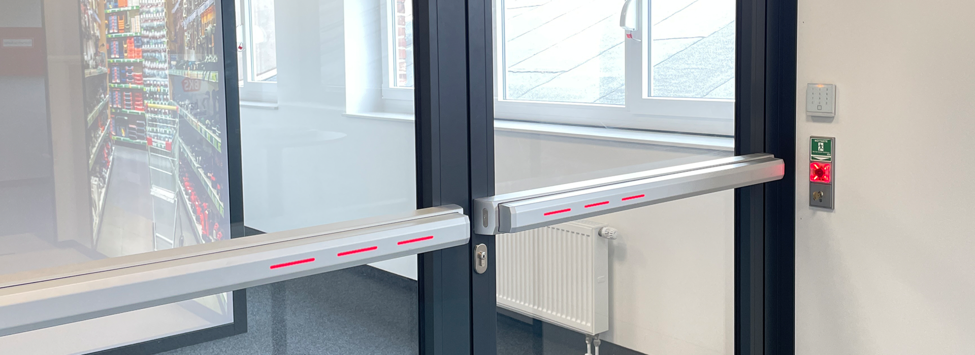 Moderne Glastür mit Panikstangen und Notausgang