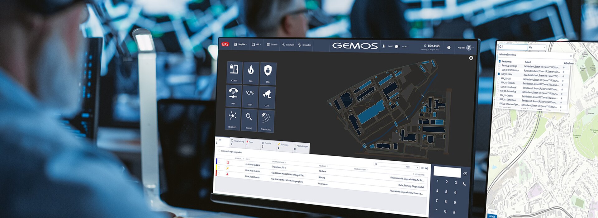 Das Gebäudemanagementsystem GEMOS im Einsatz in einer Sicherheitszentrale. Ein Mitarbeiter sitzt vor mehreren Monitoren.