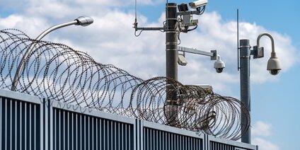 Kritische Infrastruktur KRITIS - Sicherheitszaun mit Stacheldraht und Kameras