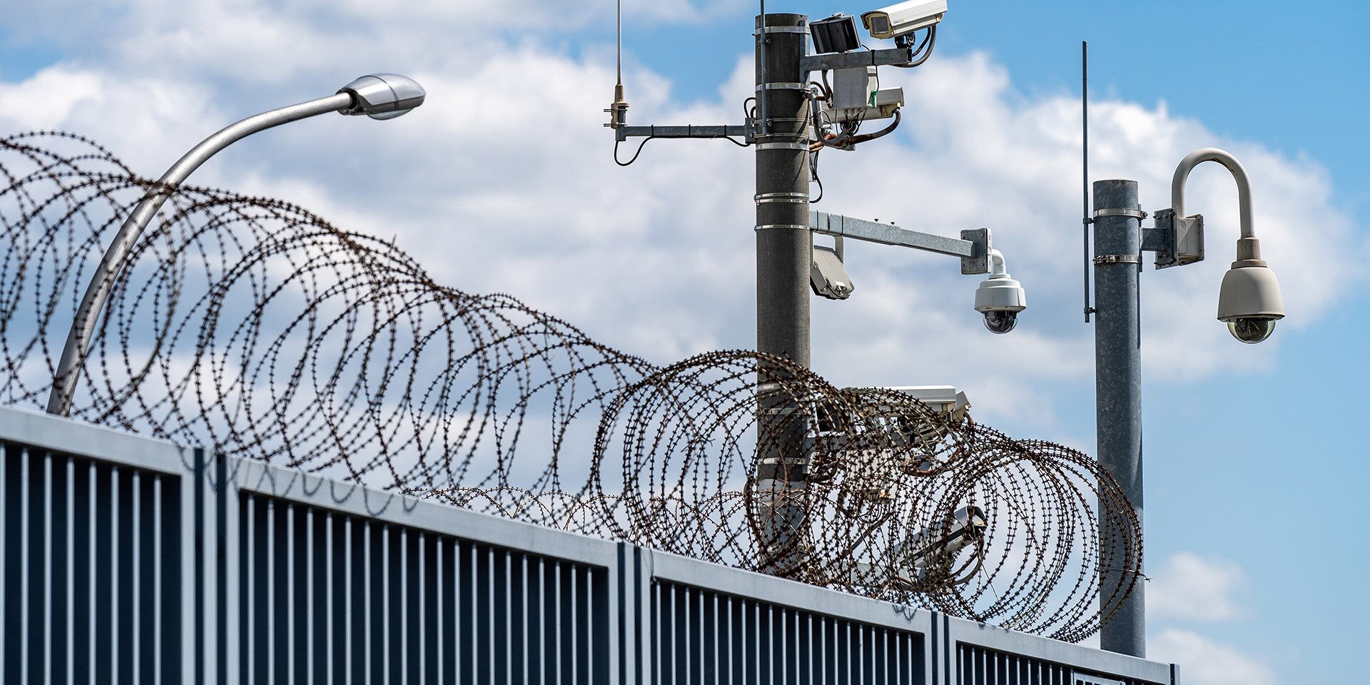 Kritische Infrastruktur KRITIS - Sicherheitszaun mit Stacheldraht und Kameras