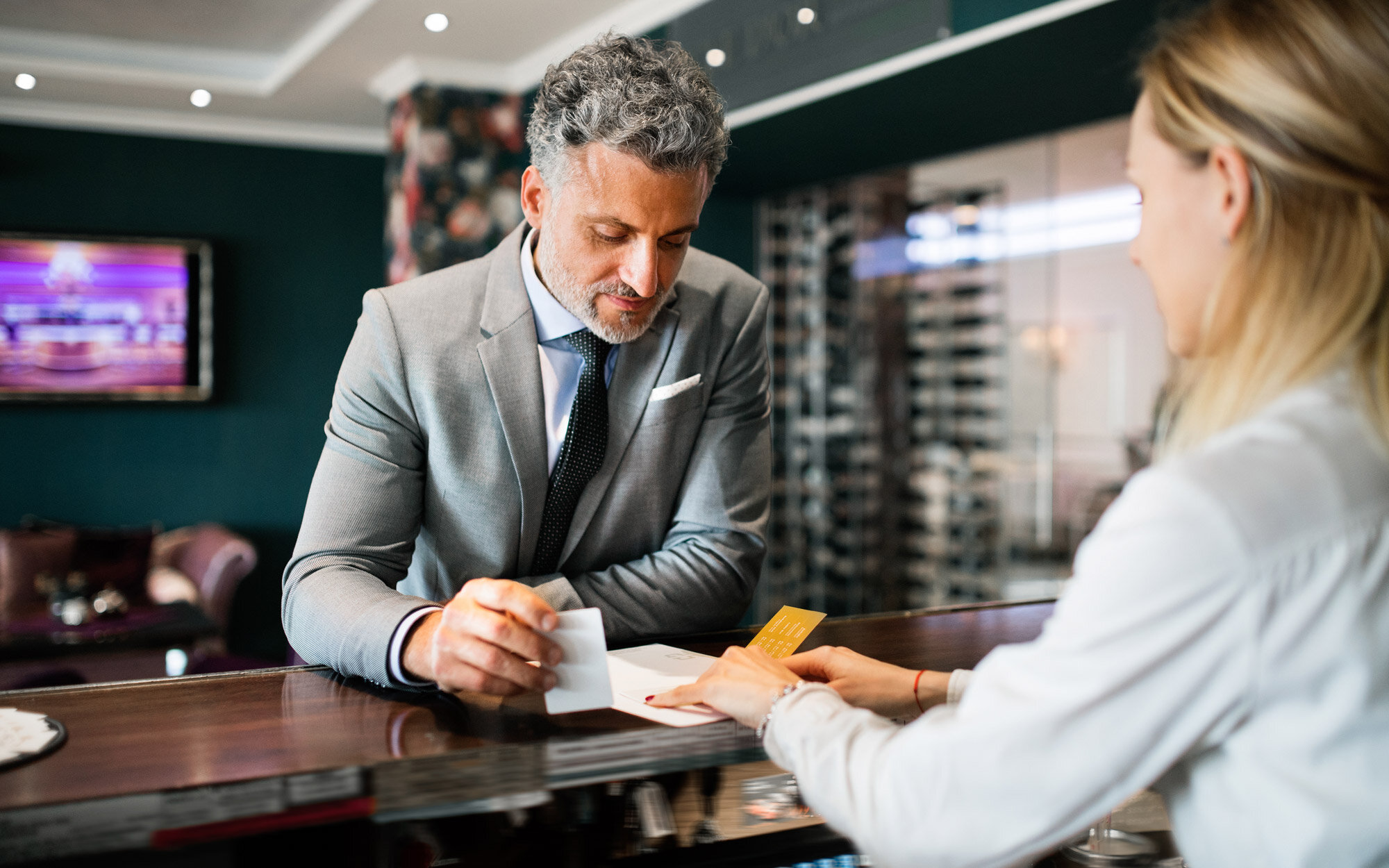Hotelgast und Rezeptionistin beim Check-in