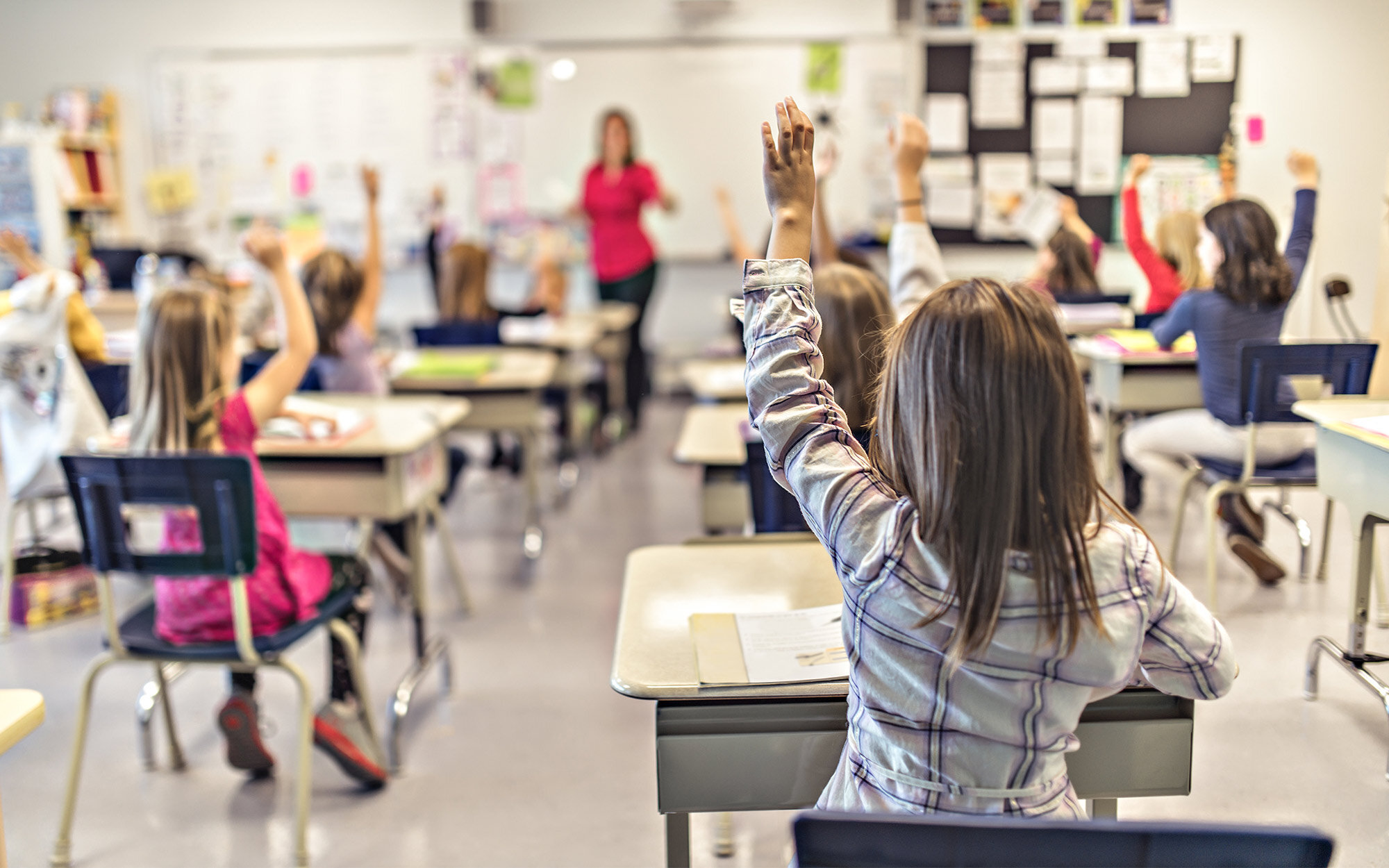 Schüler heben Hände im Unterricht