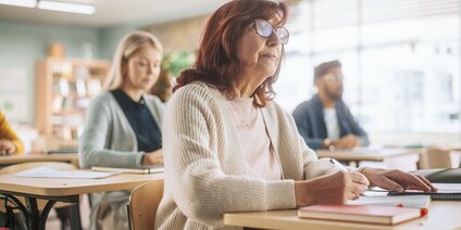 Erwachsene Frau beim Schreiben im Kurs