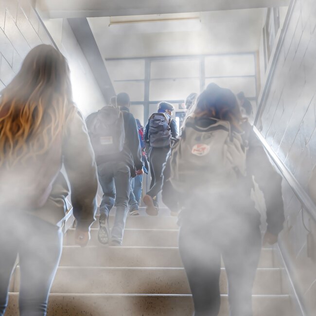 Schüler gehen Treppe im verrauchten Schulflur hoch