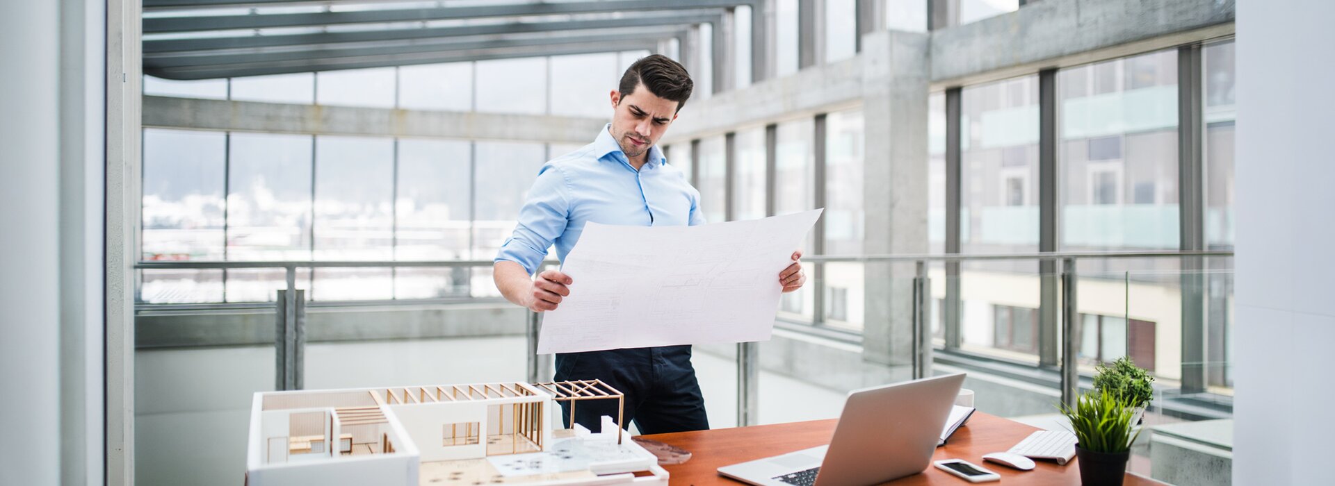 Architekt prüft Baupläne im modernen Büro