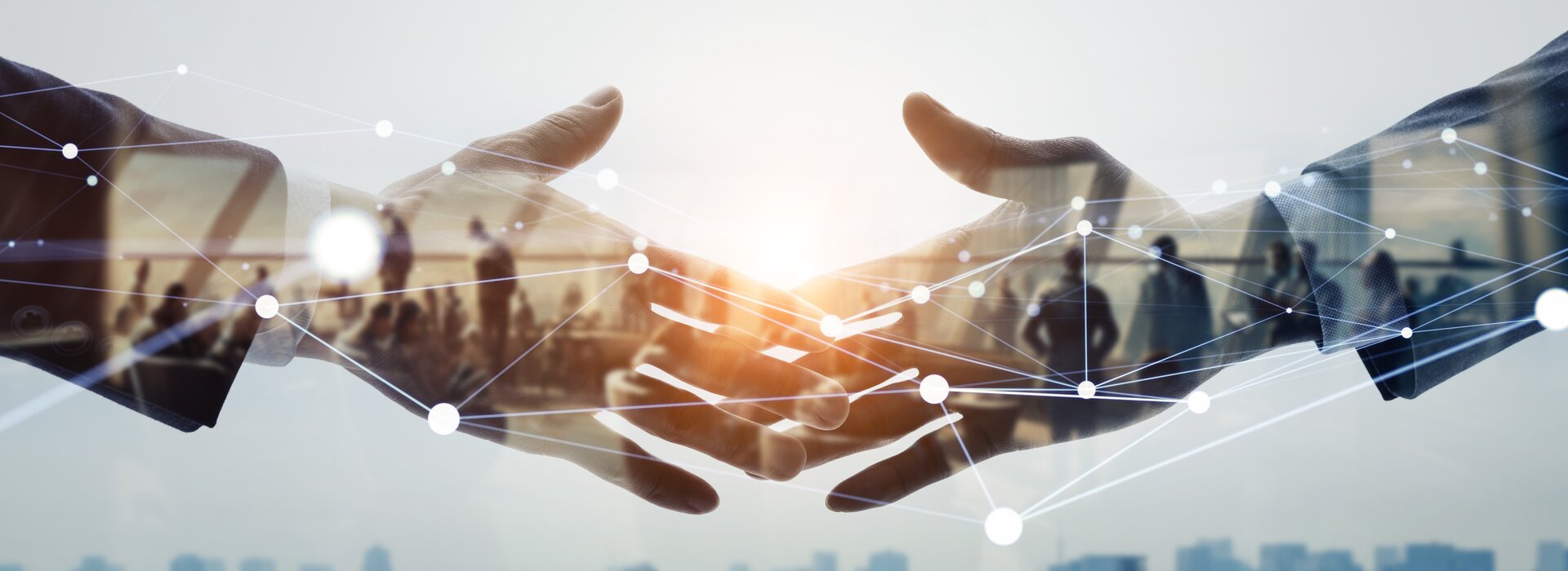 Two people shake hands and network in a professional environment.