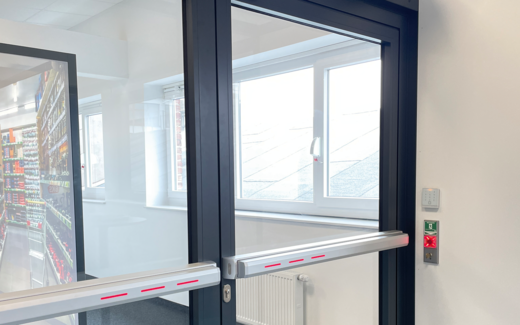 Notausgangstür mit elektrisch verriegelter Touch Bar und Fluchttürsteuerung FTNT im Gebäudeflur