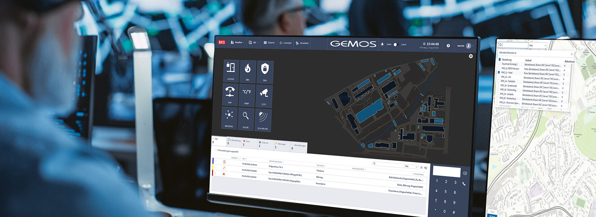 Mitarbeiter bedient das Gebäudemanagementsystem GEMOS an mehreren Monitoren in der Sicherheitszentrale