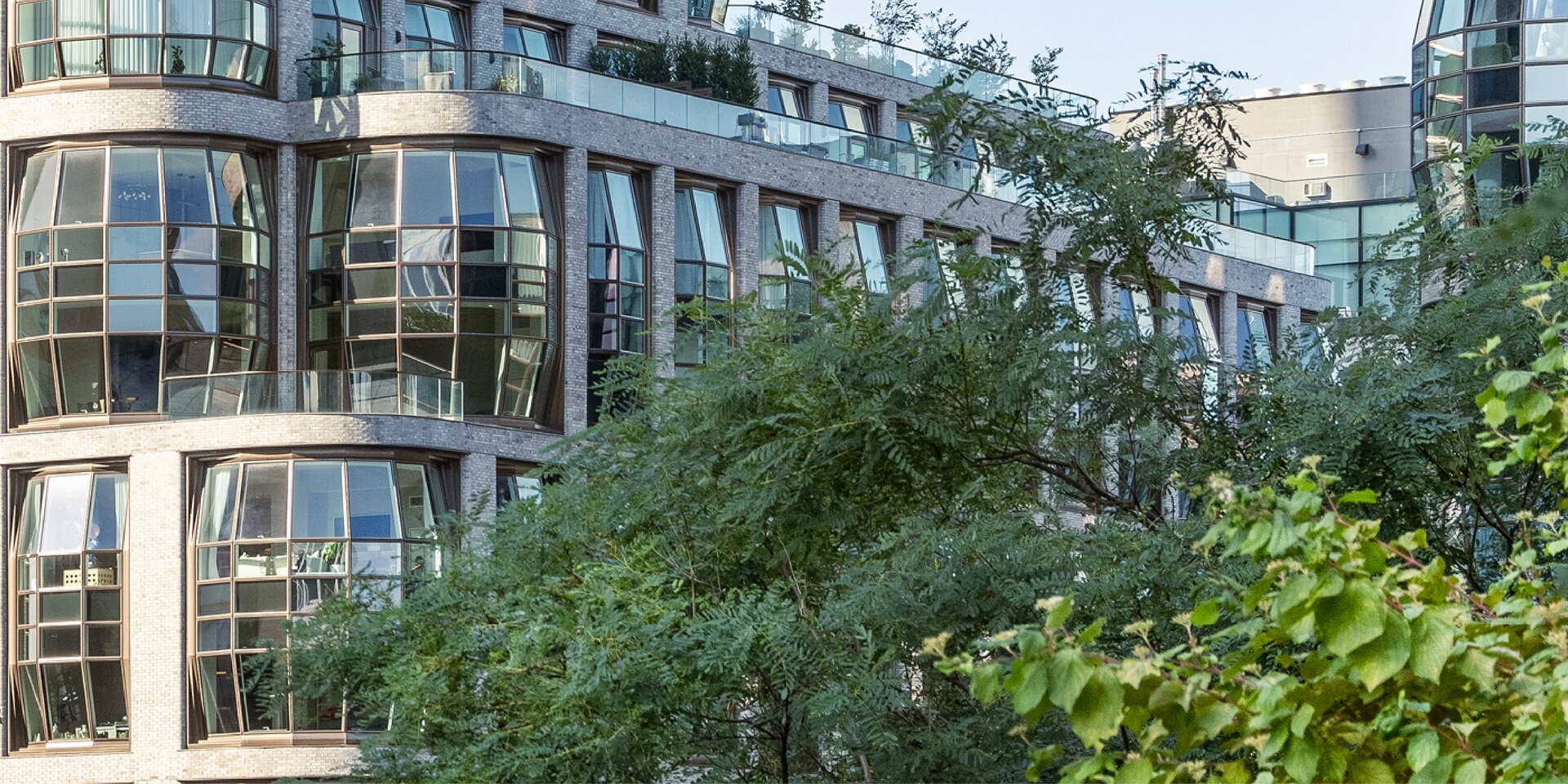 Gebäude mit Glasfassade und grünem Vordergrund