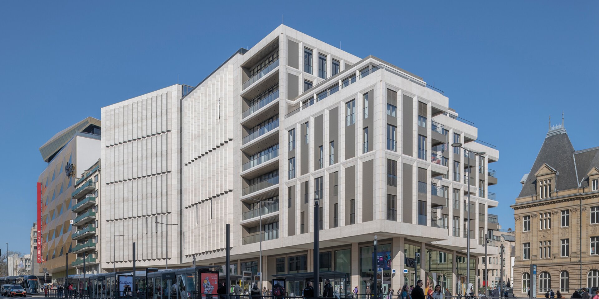 Modernes Gebäude mit Straßenbahn und Menschen